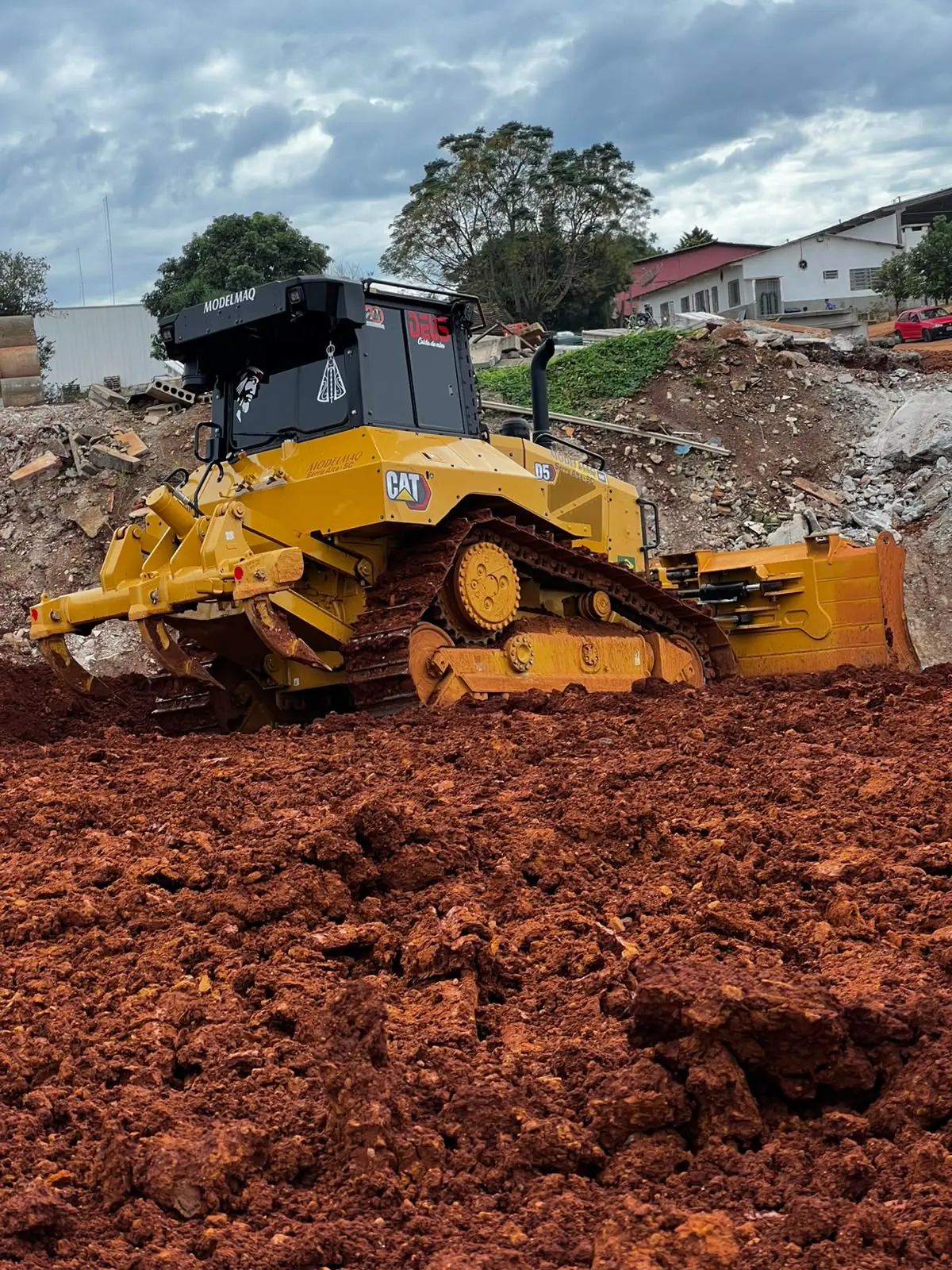 Trator de esteira D5 da MODELMAQ movimentando solo em terreno