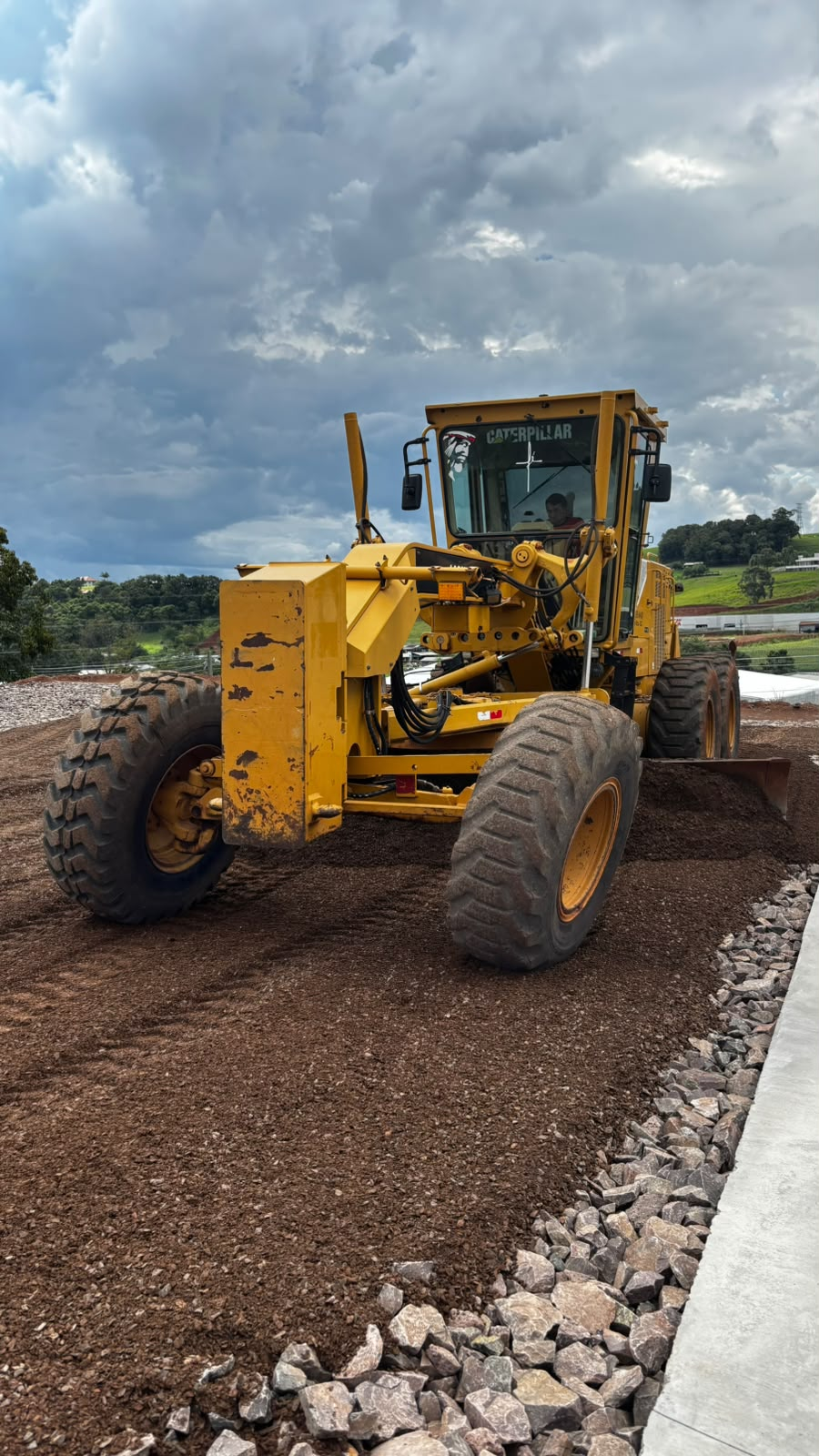 Motoniveladora Caterpillar da MODELMAQ nivelando terreno